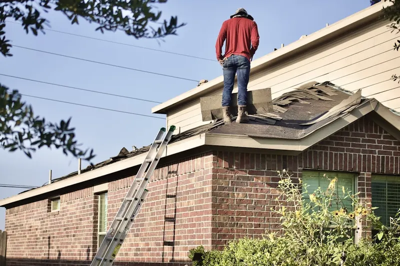 Professional roofer working on a residential roof in Village of Mount Air